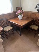 Table in closed configuration with surrounding chairs