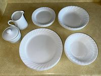 Full set arranged showing all pieces including plates, salad bowls, soup bowls, sugar bowl and cream jar.