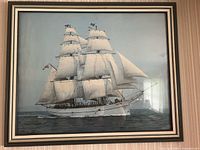 Framed color photographic print of the "Christian Radich" tall ship sailing on the sea with all sails fully deployed, showing ship details and flags, mounted under glass.