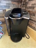 Front view of Keurig Classic coffee maker showing the water reservoir, drip tray and Keurig lid.