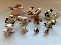 Photo of all 12 animal figurines including cats, dogs, an owl in a stroller, dogs in shoes, and small cat heads and full figures.