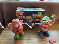 Mr. and Mrs. Potato Head figures displayed with original box in the background