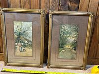 Set of 2 framed prints placed side by side showing overall view of both prints with gilded frames and matting