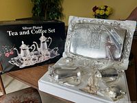 Full view of the tea and coffee set including tray, coffee pot, teapot, creamer, and sugar bowl in white tray packaging, alongside original box labeled Silver-Plated Tea and Coffee Set.