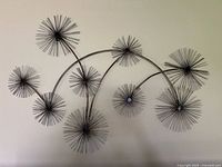 Front view of the silver and bronze abstract floral metal wall art mounted on a wall showing the entire piece and design details.