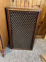 Front view of one vintage Sansui SP-100 speaker with decorative lattice wood grill and wood cabinet showing some surface wear
