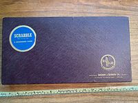 Overall view of the vintage Scrabble board game box lid with Selchow & Righter branding and minor scuffs visible on the surface.