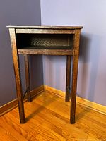 Front view of wood occasional table with open shelf, showing four legs and dark brown finish.
