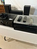 Overview of stereo equipment including Technics receiver, Kenwood DVD player, CD player, remotes, and headphones with speakers in background.