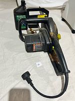 Poulan electric chainsaw with 12-inch bar, showing body, handle, and attached power cord, with visible rust and wear.