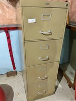 Front view of a beige 4 drawer metal filing cabinet showing all drawers closed and a lock on the top drawer.