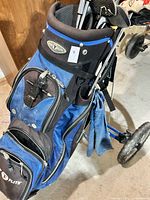 Blue Flite branded golf bag loaded with golf clubs on a push cart, displaying the exterior and compartments.