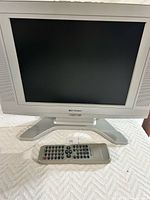 Front view of Emerson 15-inch TV/DVD player with remote laid in front.