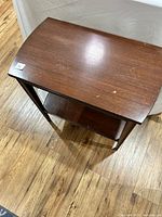Top and angled view of walnut side table showing surface marks and overall wood finish.