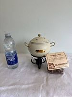 Potpourri pot with stand and herbal room scenter sachet beside a water bottle for size comparison.