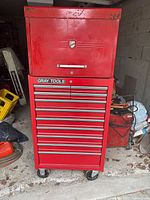 Front view of stacked red metal tool chests on caster wheels