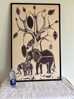 Full front view of framed batik print with water bottle for scale