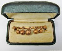 Bar pin displayed inside open leather box, full view