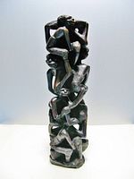 Front view of the vertical 'Family Tree of Life' sculpture showing intertwined human figures carved from dark ebony wood.