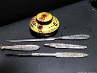 Top-view of yellow enamel inkwell and all silver-plated desk pieces laid flat