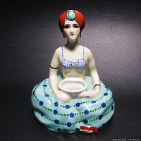 Front view of the ceramic Art Deco incense burner showing the seated woman figure with red turban and polka dot skirt holding an incense bowl.