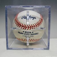Front view of sealed clear plastic display case showing Rawlings logo and Official Major League Baseball text.