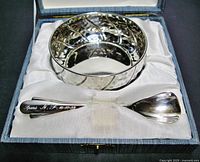 Boxed set of Italian 800 silver bowl and spoon shown inside lined box. Bowl has a hammered texture and spoon handle is engraved. Box interior satin lined with printed silver purity mark.
