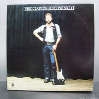 Front cover of Eric Clapton Just One Night double album vinyl showing the artist standing with guitar against black backdrop.