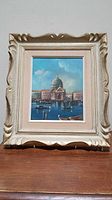 Framed oil painting showing Venice cityscape with domed building and water, complete view showing the frame and painting.