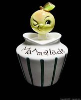 Front view of vintage marmalade jar showing the lemonhead lid and vertical green stripes with the word 'Marmalade'.