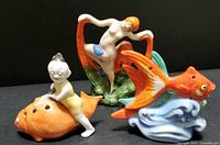 Lot of three vintage ceramic figures: nude lady, fish on wave, and boy on fish.