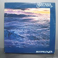 Front cover of Santana Moonflower vinyl record album showing a cloudy landscape below purple and white mountain ridges under a blue sky.