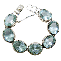 Top view of entire bracelet showing seven aqua blue glass ovals set in sterling silver links