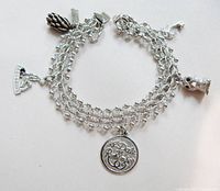 Full view of the sterling silver charm bracelet displaying all five charms and clasp
