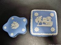 Top view of two Wedgwood jasperware boxes showing white relief classical figures on blue bases