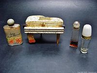 Full view of the vintage piano perfume ensemble with the two bottles inside and the three small purse size bottles grouped together.
