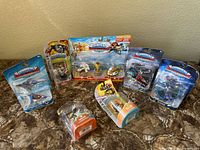 Full lot overview showing all 7 packaged Skylanders toys on marble surface.
