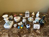 Full lot displayed on marble table including various ceramic miniatures and decorative items