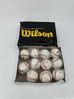 Box containing one dozen Wilson official baseballs, some individually wrapped in plastic.