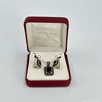 Jewelry suite displayed in a red jewelry box with a pendant and matching earrings, showing polished onyx stones framed by marcasite accents in sterling silver.