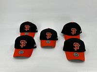 Five San Francisco Giants hats, black with orange brims and logos, arranged on white background.