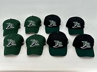 Eight Tampa Bay Rays caps arranged in two rows of four, showing the front embroidered 'TB' logos. Four caps are green, four are black with green bills.