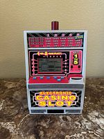 Front view of the toy arcade machine showing the colorful casino slot machine front.