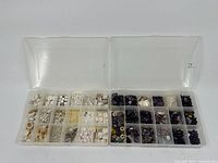 Full view of two open plastic bead trays, one light-colored beads and one dark purple amethyst beads.