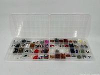 Two clear plastic bead trays showing various colors and shapes of beads organized in compartments