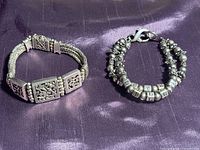 Both sterling silver bracelets on purple fabric background, showing overall appearance and design.