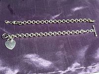 Two sterling silver chain bracelets displayed on purple fabric, showing overall length and chain style.