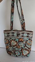 Front view of large Vera Bradley purse showing floral quilted pattern and long straps.