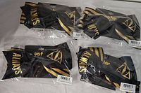 Four individually packaged Harry Potter hair bows displayed on a surface, showing black fabric with gold stripes, 'Always' text, and Deathly Hallows symbols.