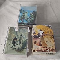 Photo of assorted non-sports trading cards, some in protective cases with illustrated fantasy artwork.